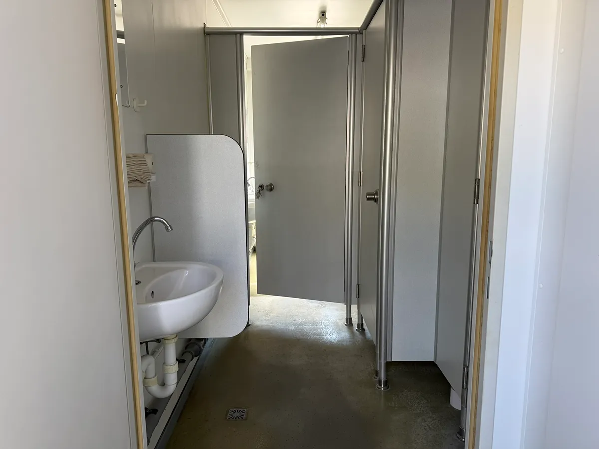 Gebrauchter Sanitärcontainer Innenansicht mit Waschbecken und offenem Durchgang