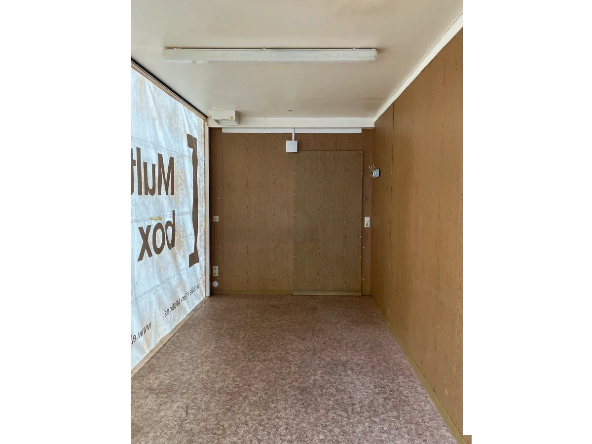 Gebrauchter Bürocontainer Innenraum mit Holzwandverkleidung Eingangstür und Deckenleuchte