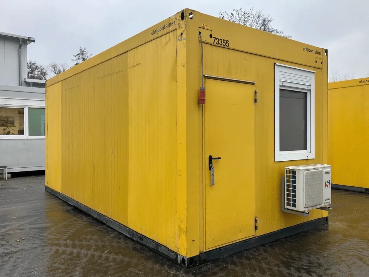 Gebrauchter 20 Fuß Bürocontainer gelb von ELA Container mit offener Seitenfront und Glastür – Außenansicht schräg von hinten