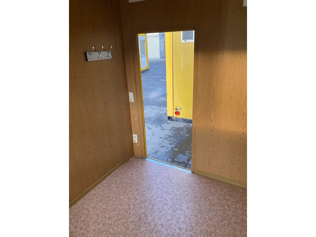 Gebrauchter 10 Fuß Bürocontainer Innenraum mit Holzpaneelen und offener Eingangstür
