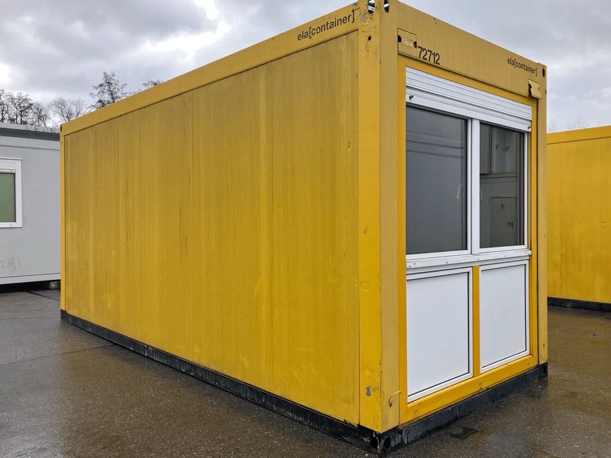 Gebrauchter 20 Fuß Bürocontainer gelb von ELA Container mit Fensterelement und Rolllade – Frontansicht auf dem Containerplatz