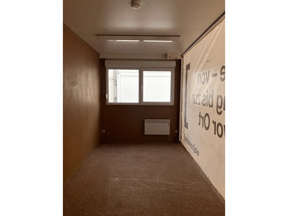 Gebrauchter 20 Fuß Bürocontainer Innenansicht mit Fenster, Konvektorheizung und Deckenbeleuchtung – Blick Richtung Fensterseite