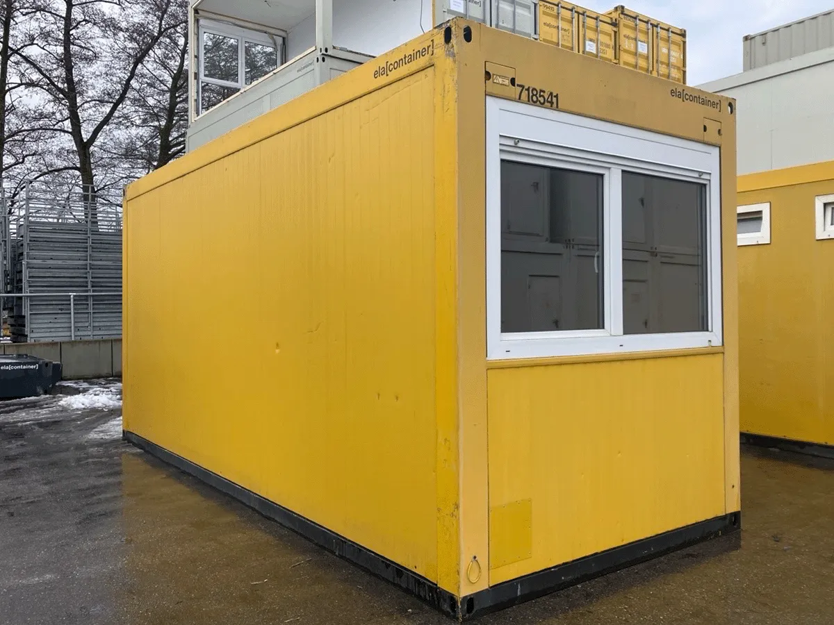 Gebrauchter 20 Fuß Bürocontainer gelb von ELA Container mit großem Fenster – Frontansicht auf dem Containerplatz