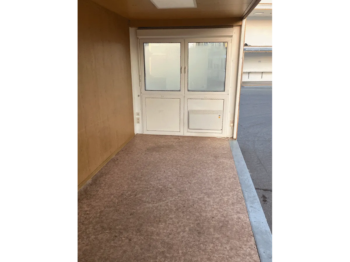 Gebrauchter 20 Fuß Bürocontainer Innenansicht mit weißer Doppeltür und OSB-Wandverkleidung – Blick zum Ausgang