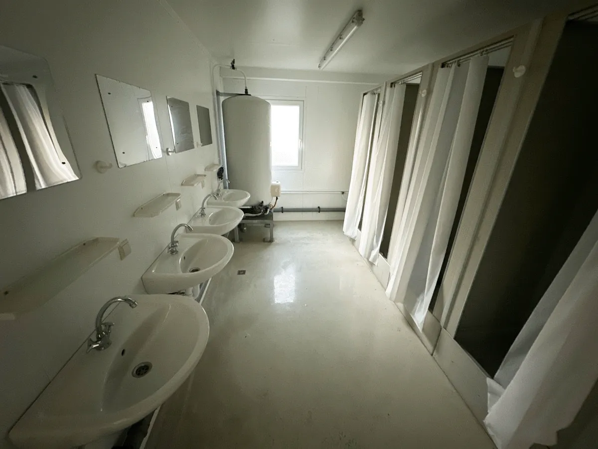 Innenraum mit Waschbecken und Duschkabinen