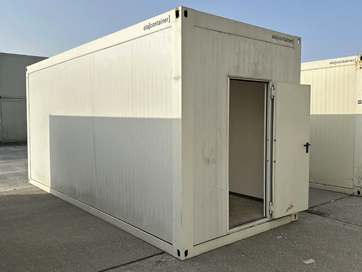 Rückansicht eines gebrauchten grauen Bürocontainers mit geschlossener Eingangstür und seitlicher Perspektive.