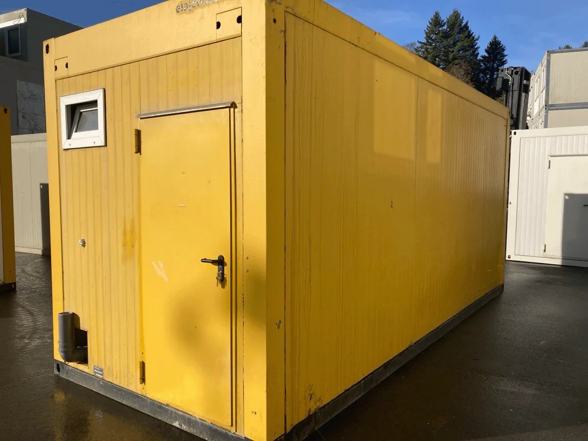 Gebrauchter 20 Fuß Bürocontainer gelb mit Eingangstür und Lüftungsöffnung – Außenansicht Türseite auf dem Containerplatz