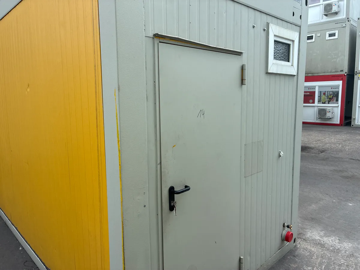 Gebrauchter Bürocontainer ELA Container gelb mit grauer Außentür, Außenansicht