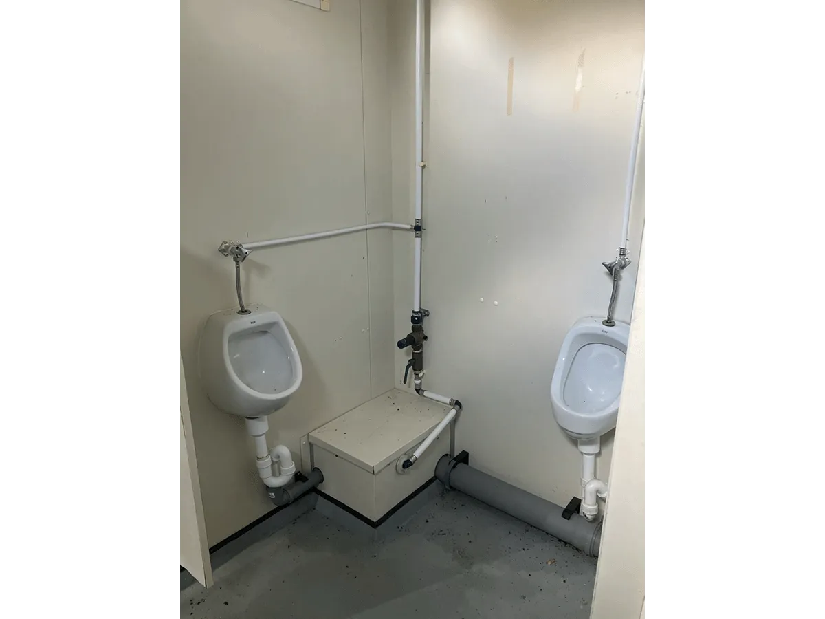 Urinale im Sanitärcontainer mit Leitungen