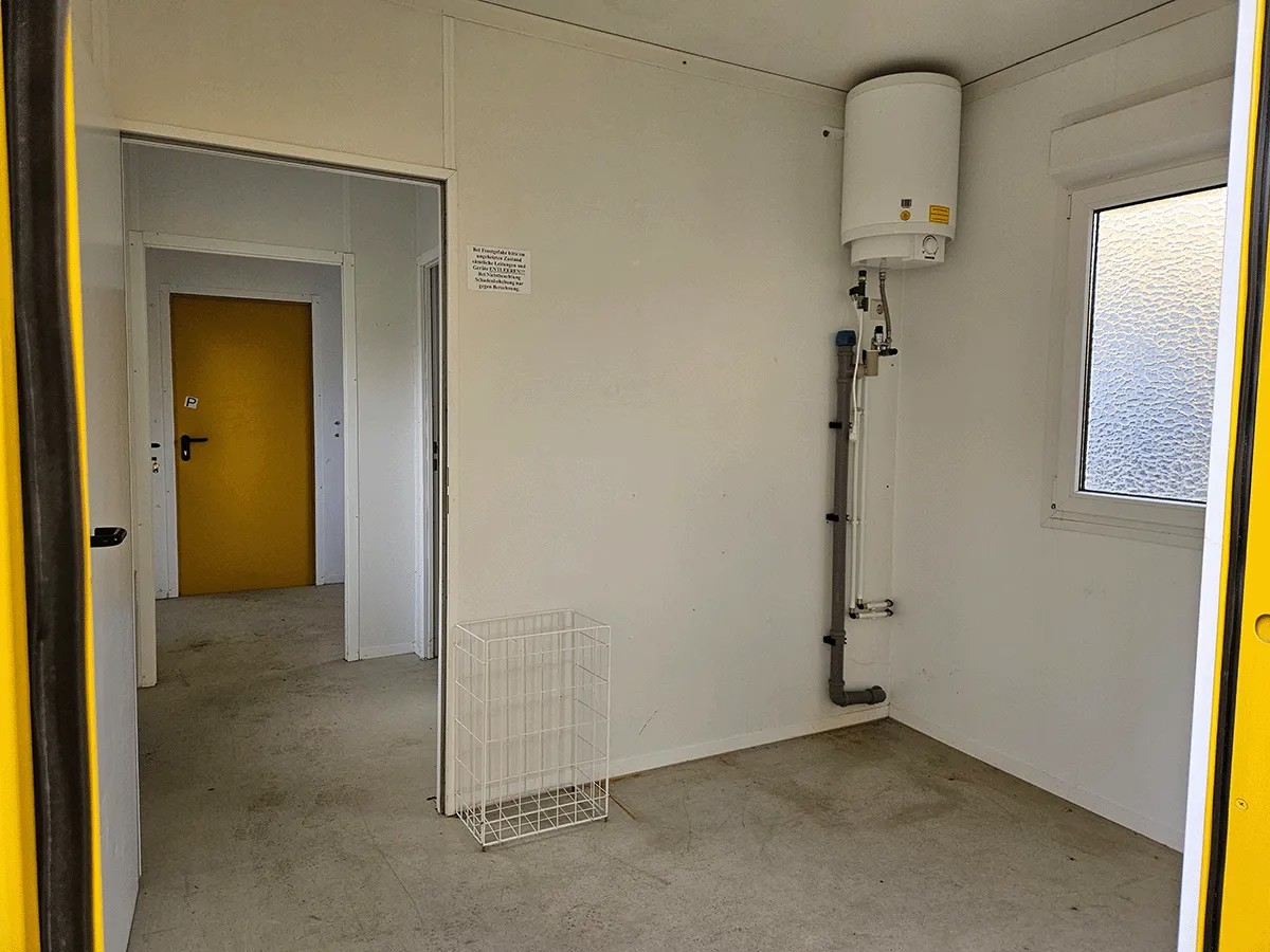 buerocontainer innenraum mit warmwasserboiler und anschluessen sanitärcontainer kombi
