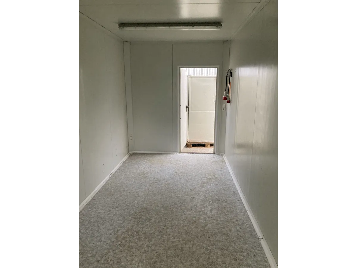 Gebrauchter 20 Fuß Bürocontainer Innenraum mit offener Eingangstür und Feuerlöscher