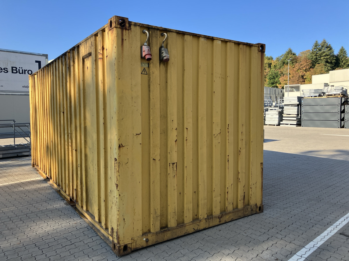 Gebrauchter gelber Container mit zwei CEE-Steckdosen, Außenansicht auf dem Betriebsgelände