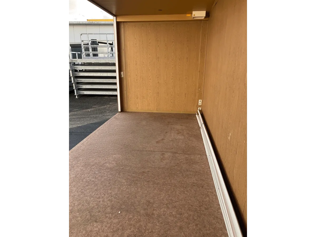 Gebrauchter 20 Fuß Bürocontainer Innenansicht mit offener Seitenfront, Kabelkanal und OSB-Wandverkleidung – Blick nach außen
