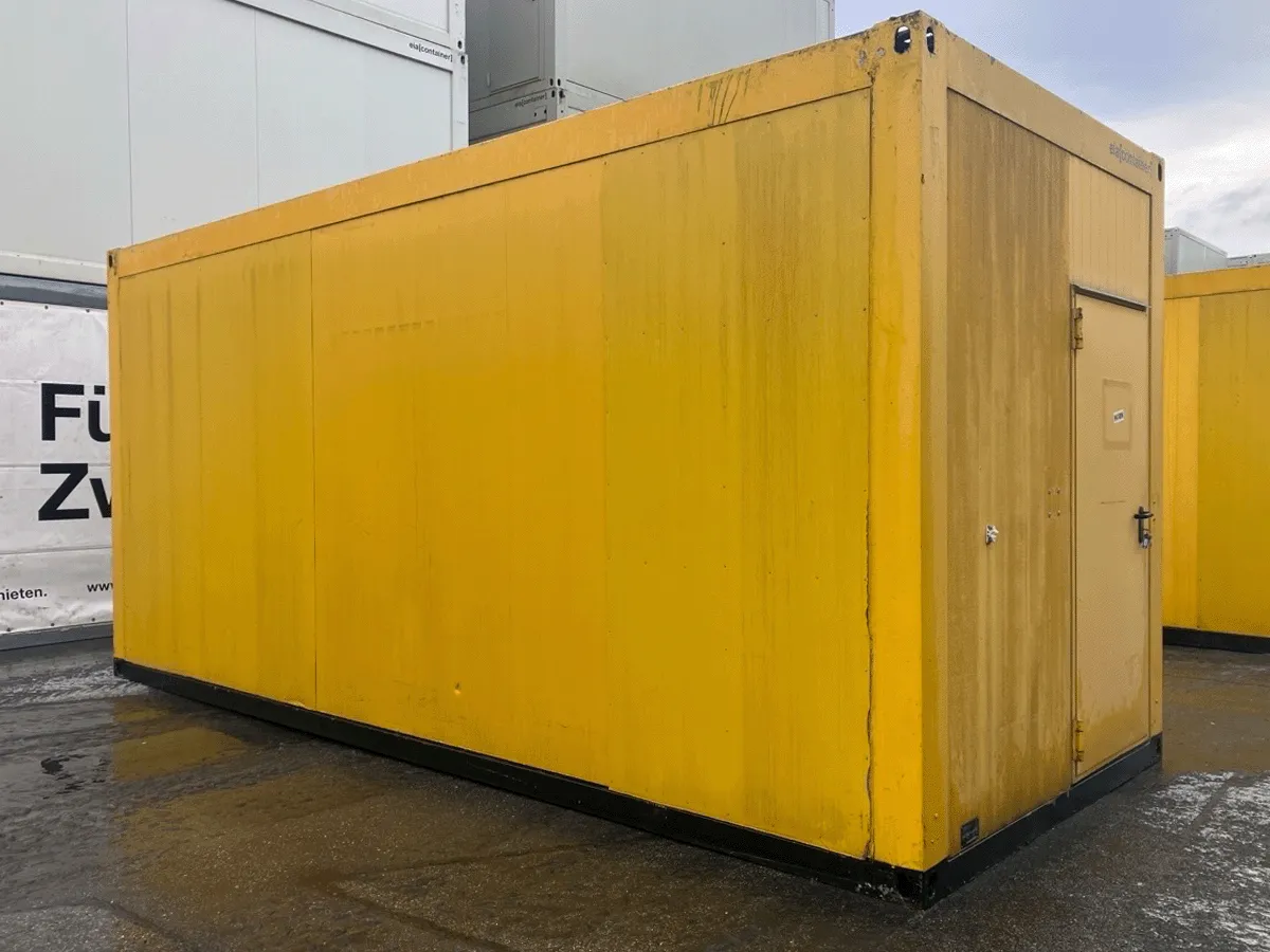 Gebrauchter 20 Fuß Bürocontainer gelb mit Eingangstür – Rückansicht seitlich auf dem Containerplatz