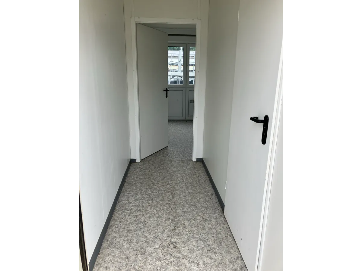 Gebrauchter WC-Container Innenansicht mit Flur und offener Tür