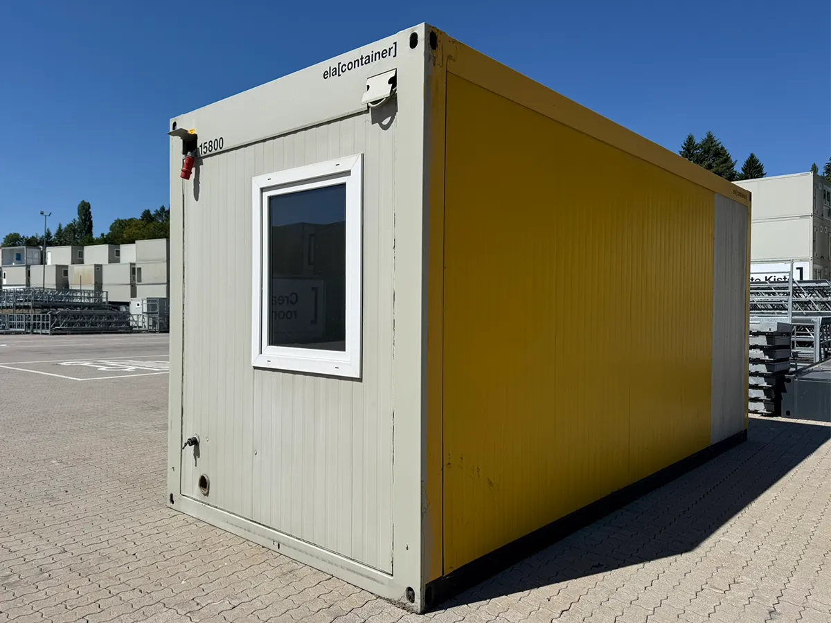 Gebrauchter Sanitärcontainer gelb mit Fenster, Außenansicht