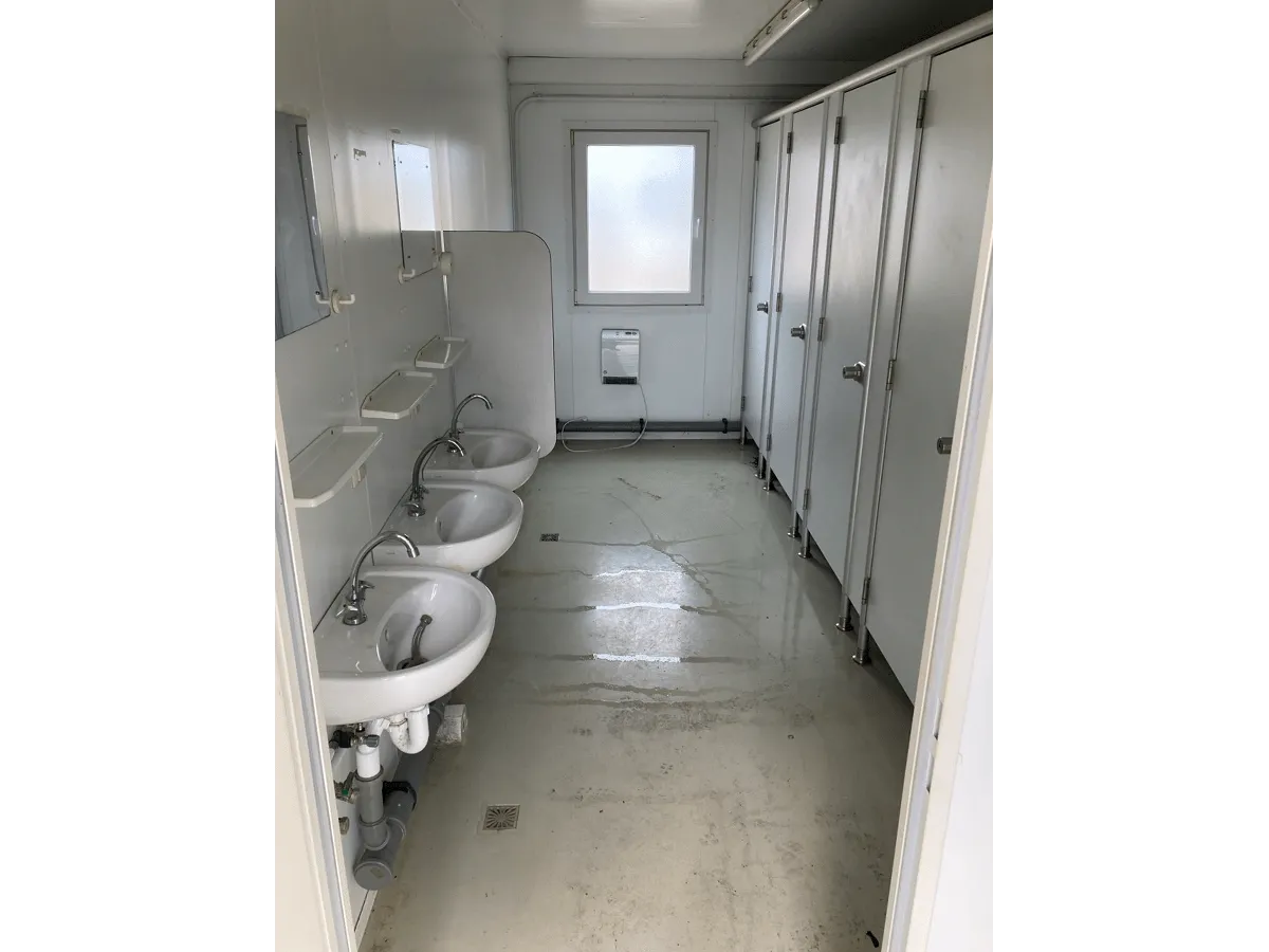 Innenansicht WC-Container mit Waschbeckenreihe und Sanitärinstallation