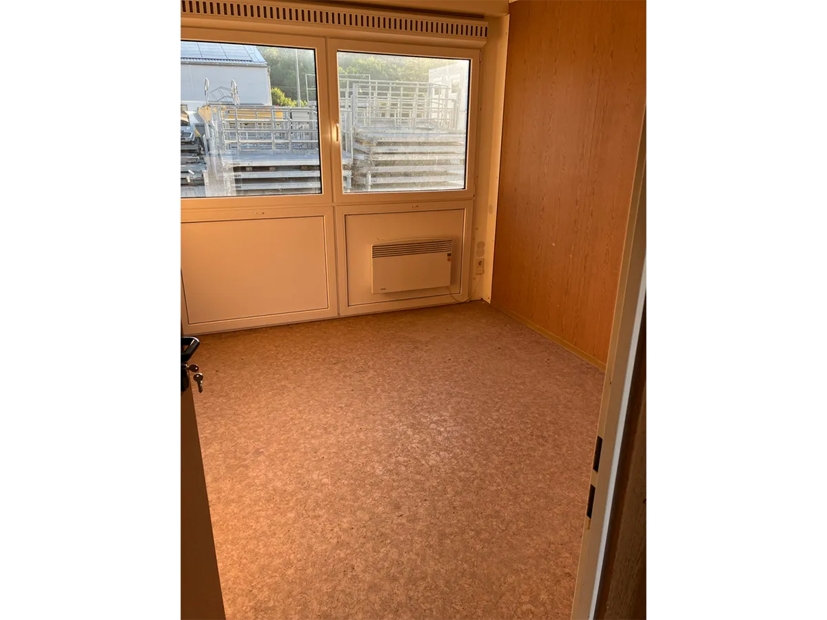 Gebrauchter Bürocontainer Innenansicht mit Fenstertür und Heizkörper