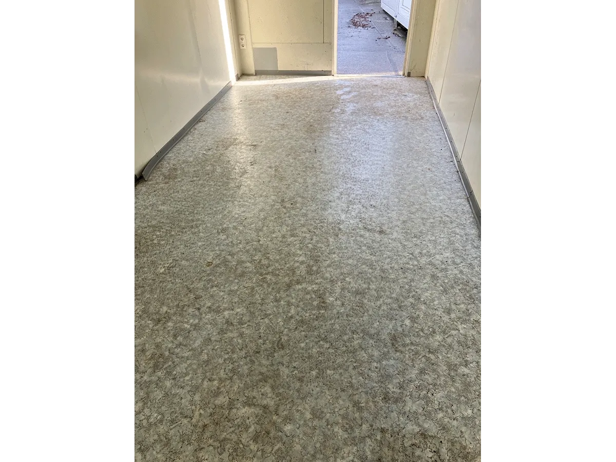 Gebrauchter Bürocontainer Innenraum Vinylboden mit Blick zur offenen Eingangstür