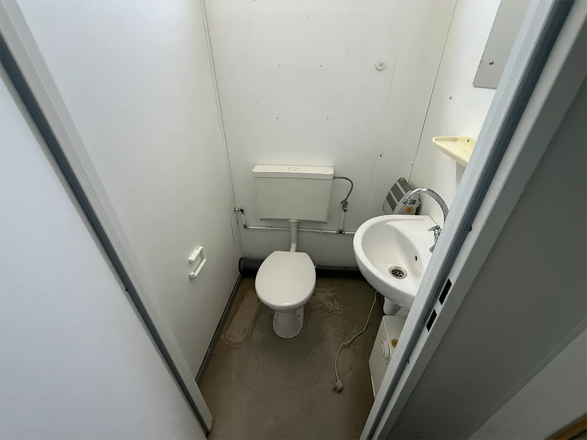 Gebrauchter Sanitärcontainer Innenansicht mit WC und Waschbecken