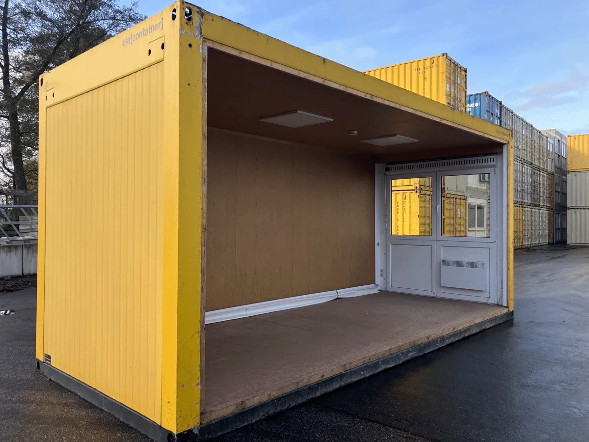 Gebrauchter 20 Fuß Bürocontainer gelb von ELA Container mit offener Seitenfront und Glastür – Außenansicht schräg von hinten