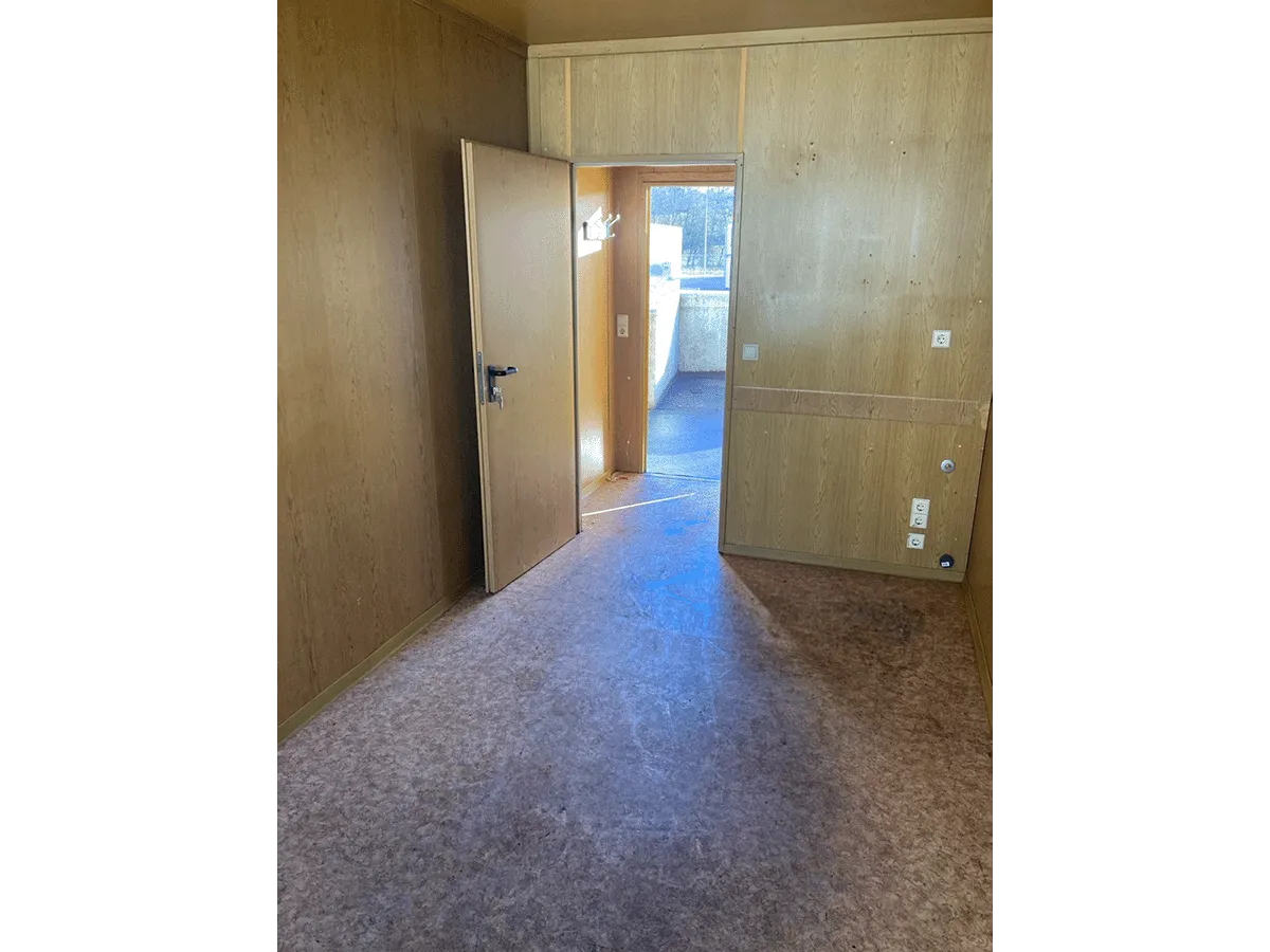 Gebrauchter 20 Fuß Bürocontainer Innenansicht mit offener Zwischentür, OSB-Wandverkleidung und Vinylboden – Blick zwischen den Räumen