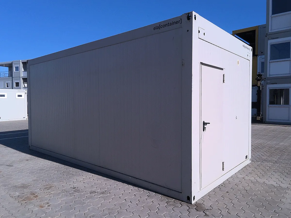 Außenansicht eines gebrauchten grauen Bürocontainers in Sonderbreite mit Doppel-Fenster und Rollladen auf einem Betriebshof.