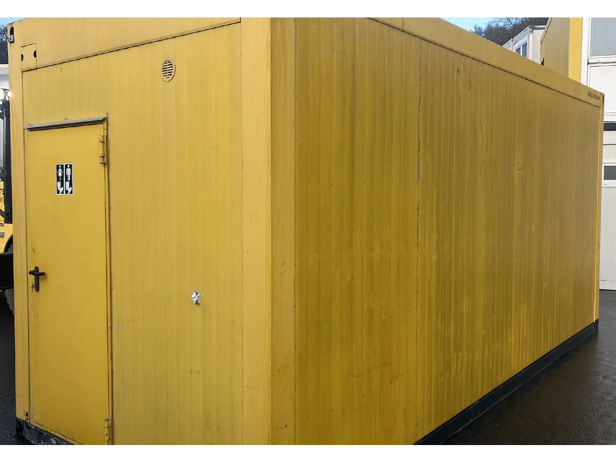 Außenansicht gelber Sanitärcontainer mit WC-Piktogramm an der Eingangstür
