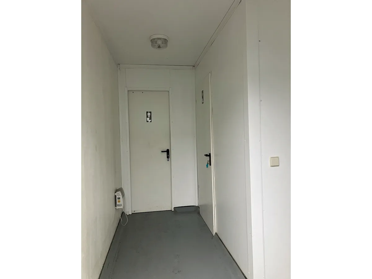 Flur im Sanitärcontainer mit Kabinentüren
