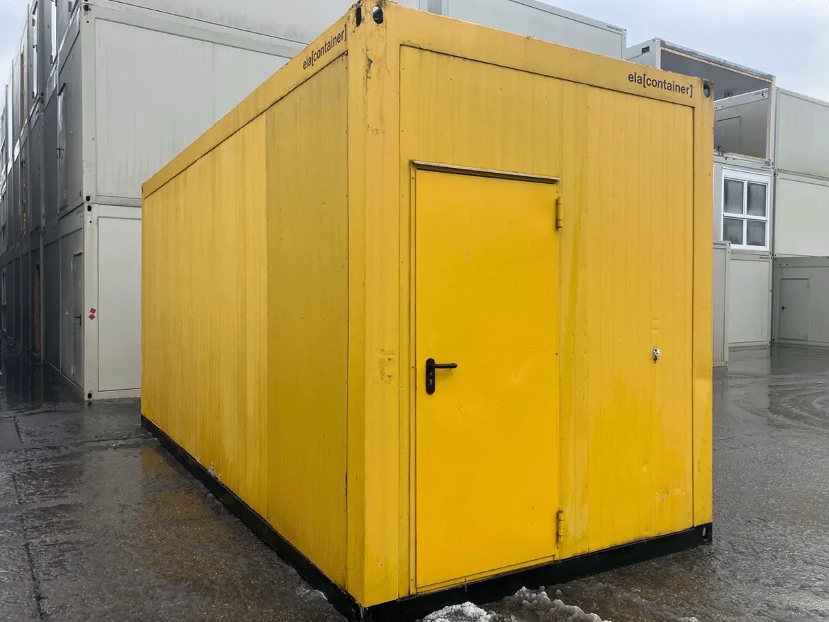 Rückansicht eines gebrauchten grauen Bürocontainers mit geschlossener Eingangstür.