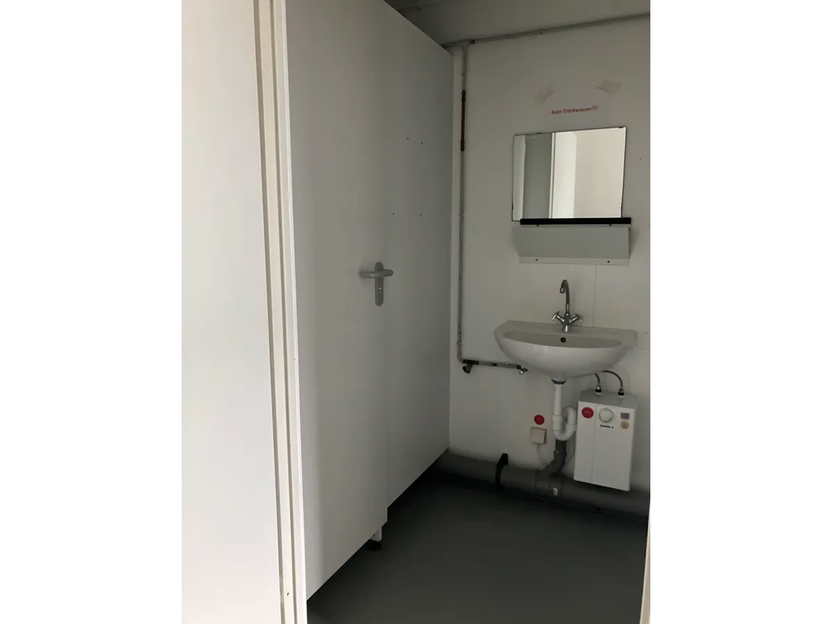 Waschbecken im Sanitärcontainer mit Spiegel