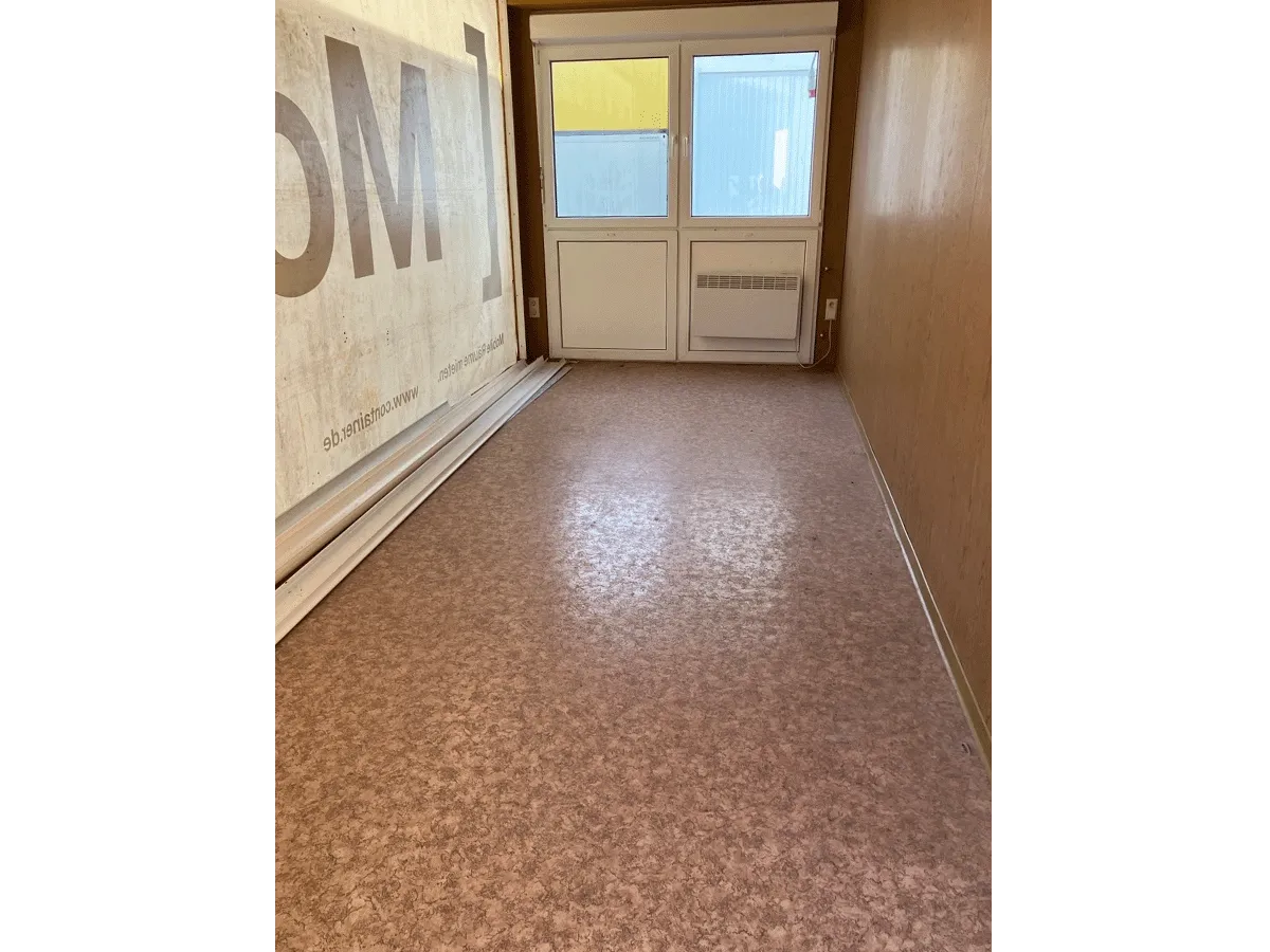 buerocontainer innenraum mit wandbanner und fenster pvc boden bueroeinheit