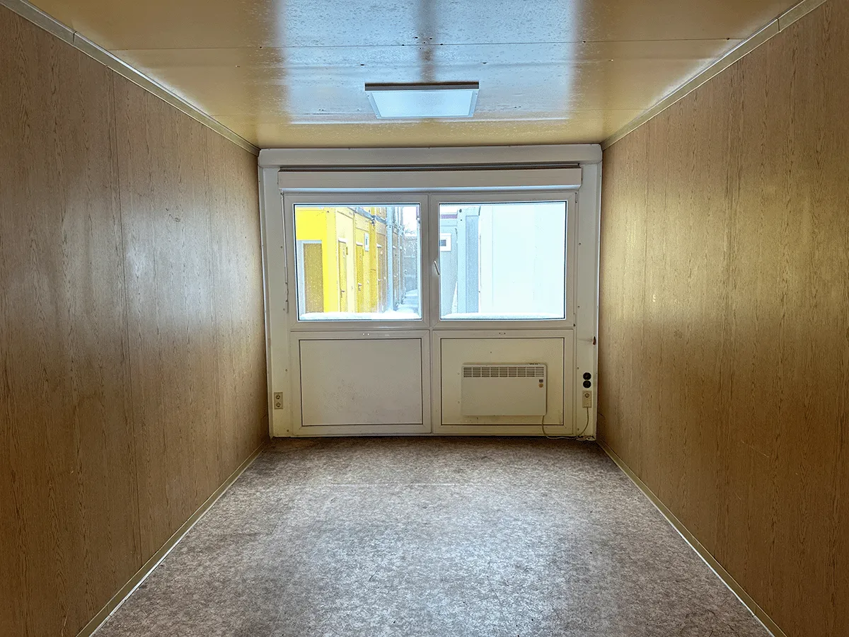 Gebrauchter 20 Fuß Bürocontainer Innenansicht mit großem Fenster, Konvektorheizung und Deckenleuchte – Blick zur Fensterseite