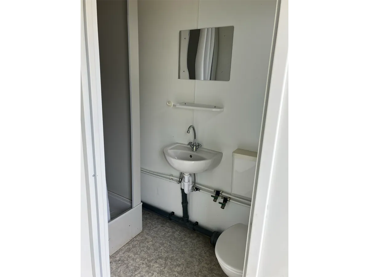 Gebrauchter WC-Container Innenansicht mit Waschbecken und Spiegel