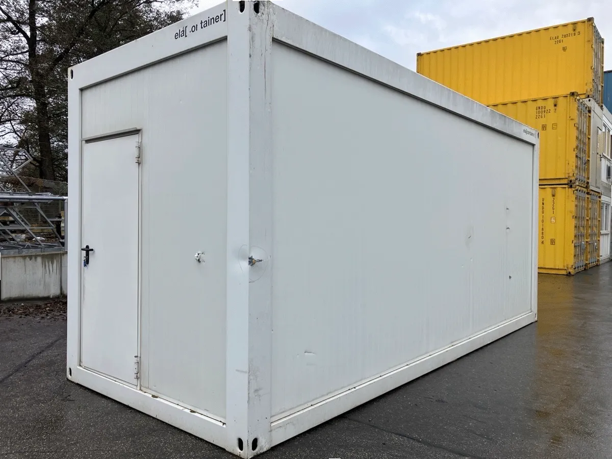 Rückansicht eines gebrauchten grauen Bürocontainers mit Eingangstür, seitliche Perspektive.