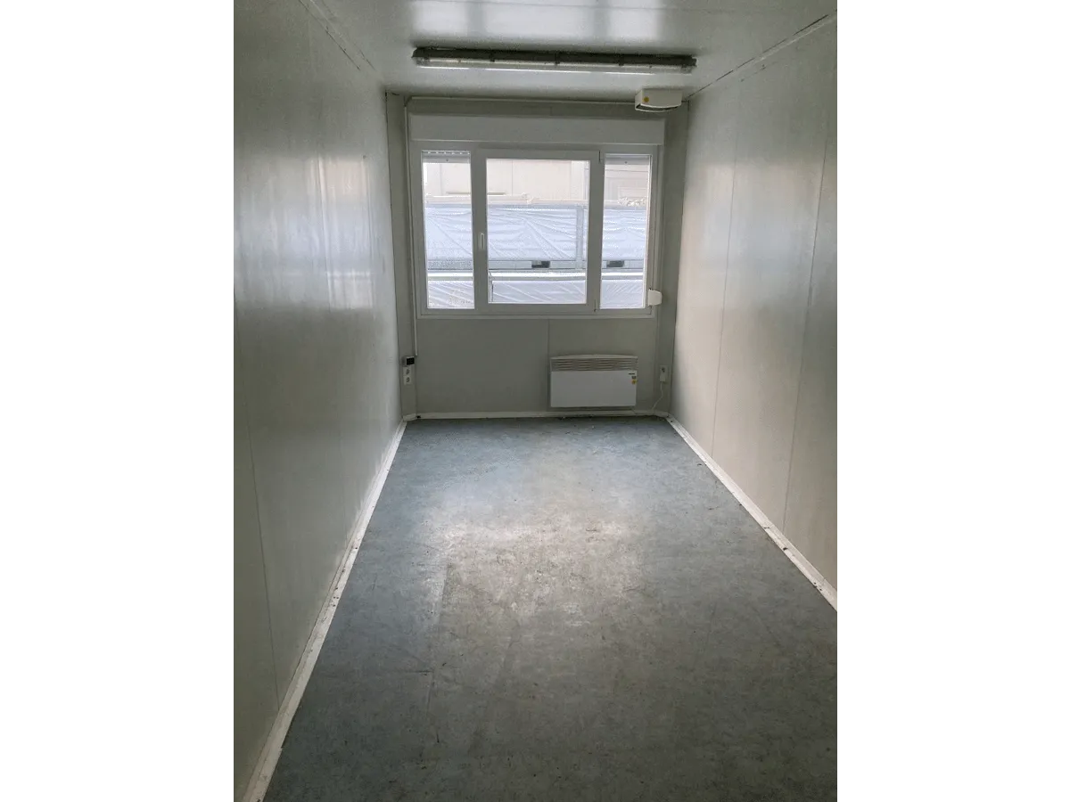 Gebrauchter 20 Fuß Bürocontainer Innenansicht mit Fenster, Heizkörper und Neonbeleuchtung – heller Innenraum