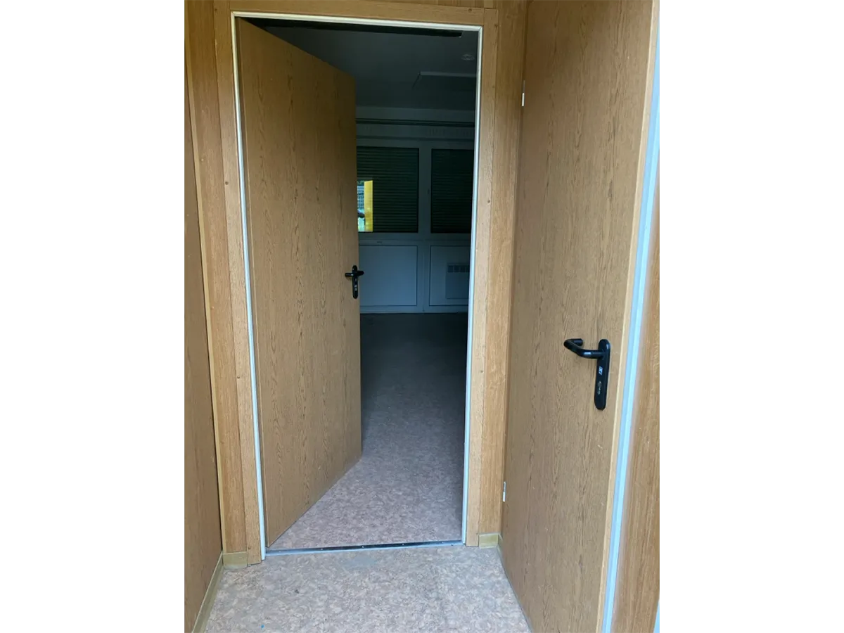 Gebrauchter Bürocontainer Innenansicht mit offener Tür und Flur