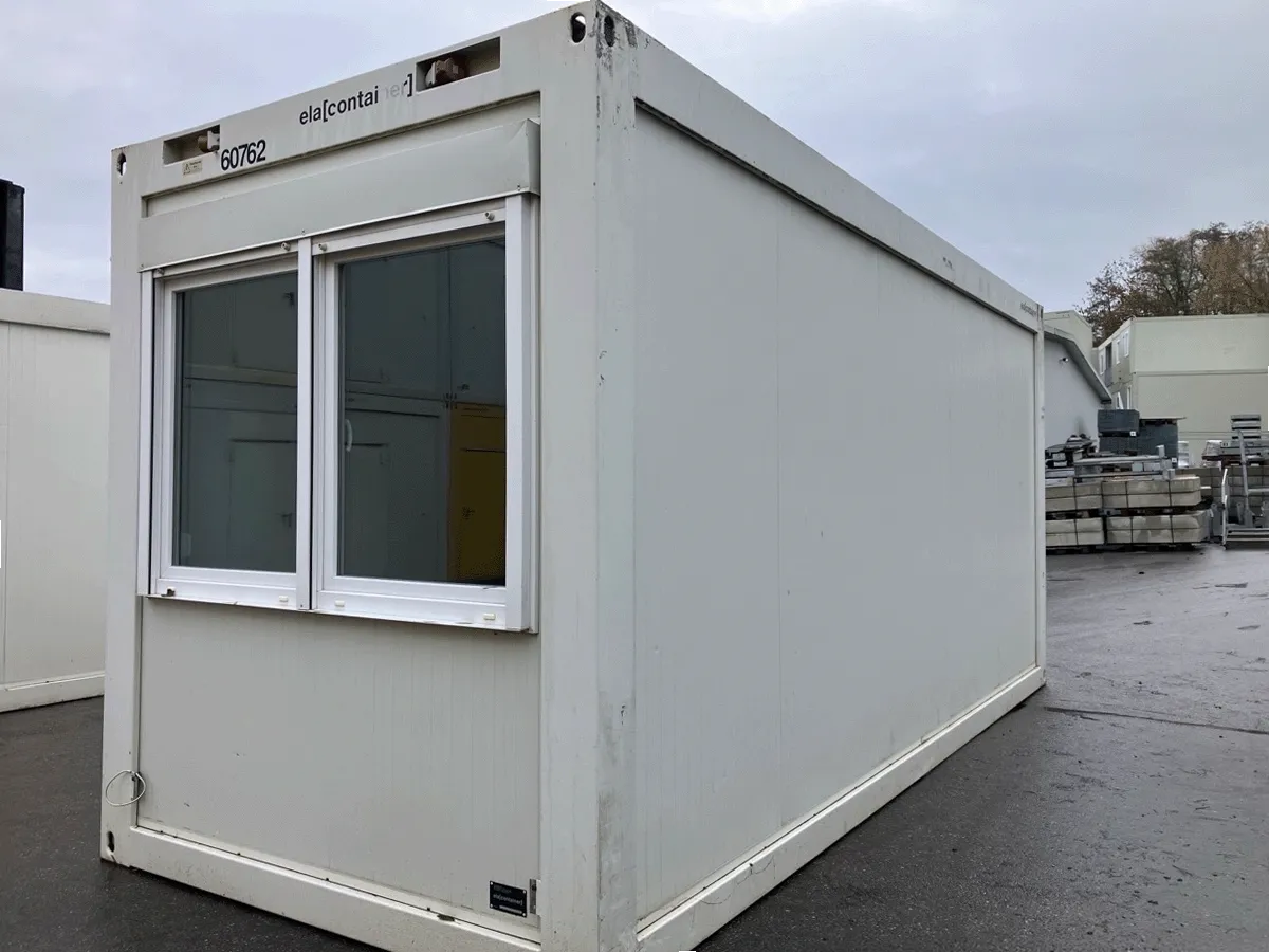 Gebrauchte, graue Bürocontainer in einer Reihe, Frontansicht mit Doppel-Fenster.