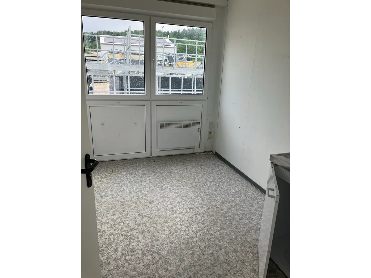 Gebrauchter WC-Container Innenansicht mit Doppelfenster und hellem Boden
