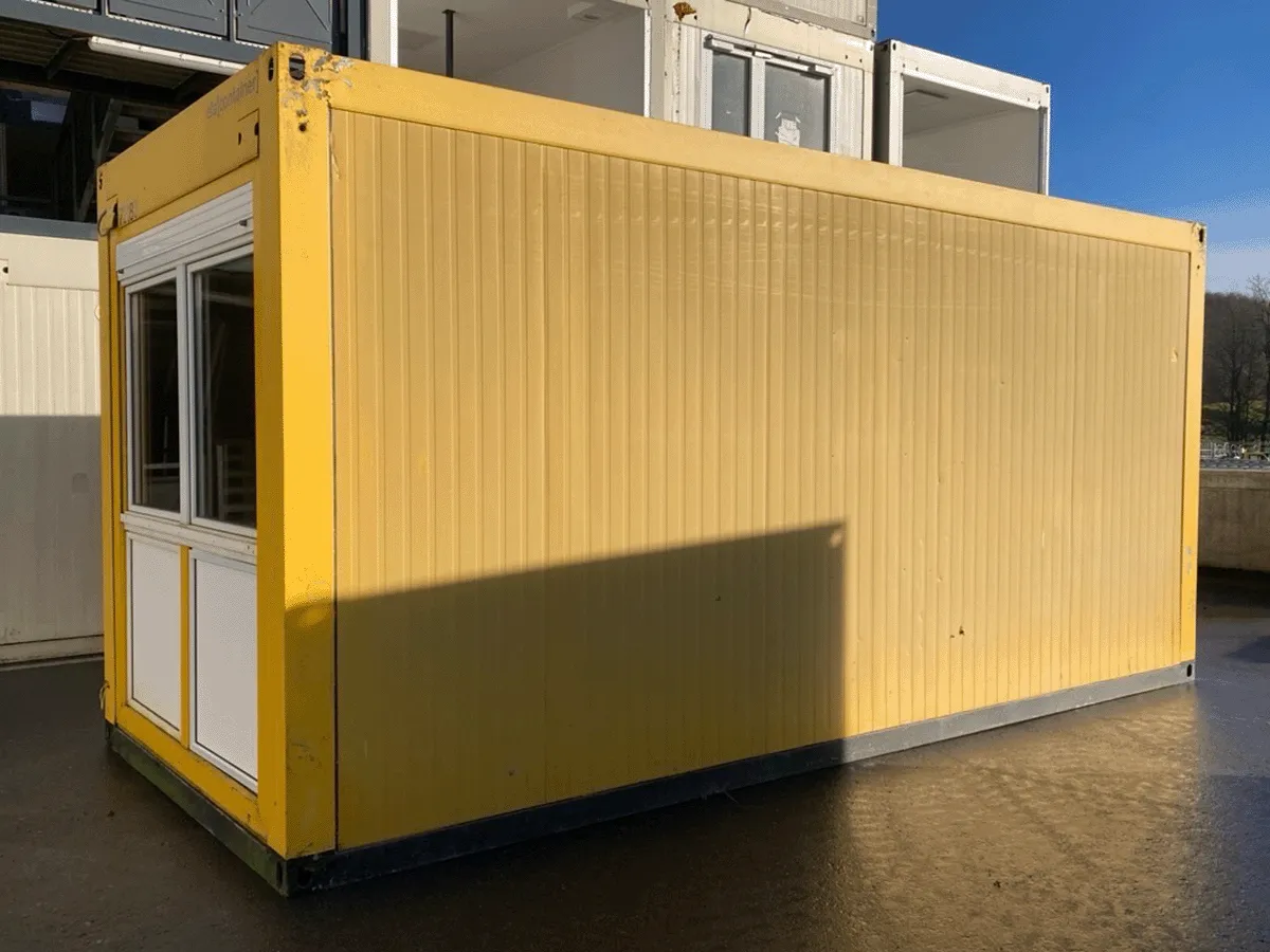 Gebrauchter 20 Fuß Bürocontainer gelb mit großem Fensterelement – Außenansicht Fensterseite schräg von vorne