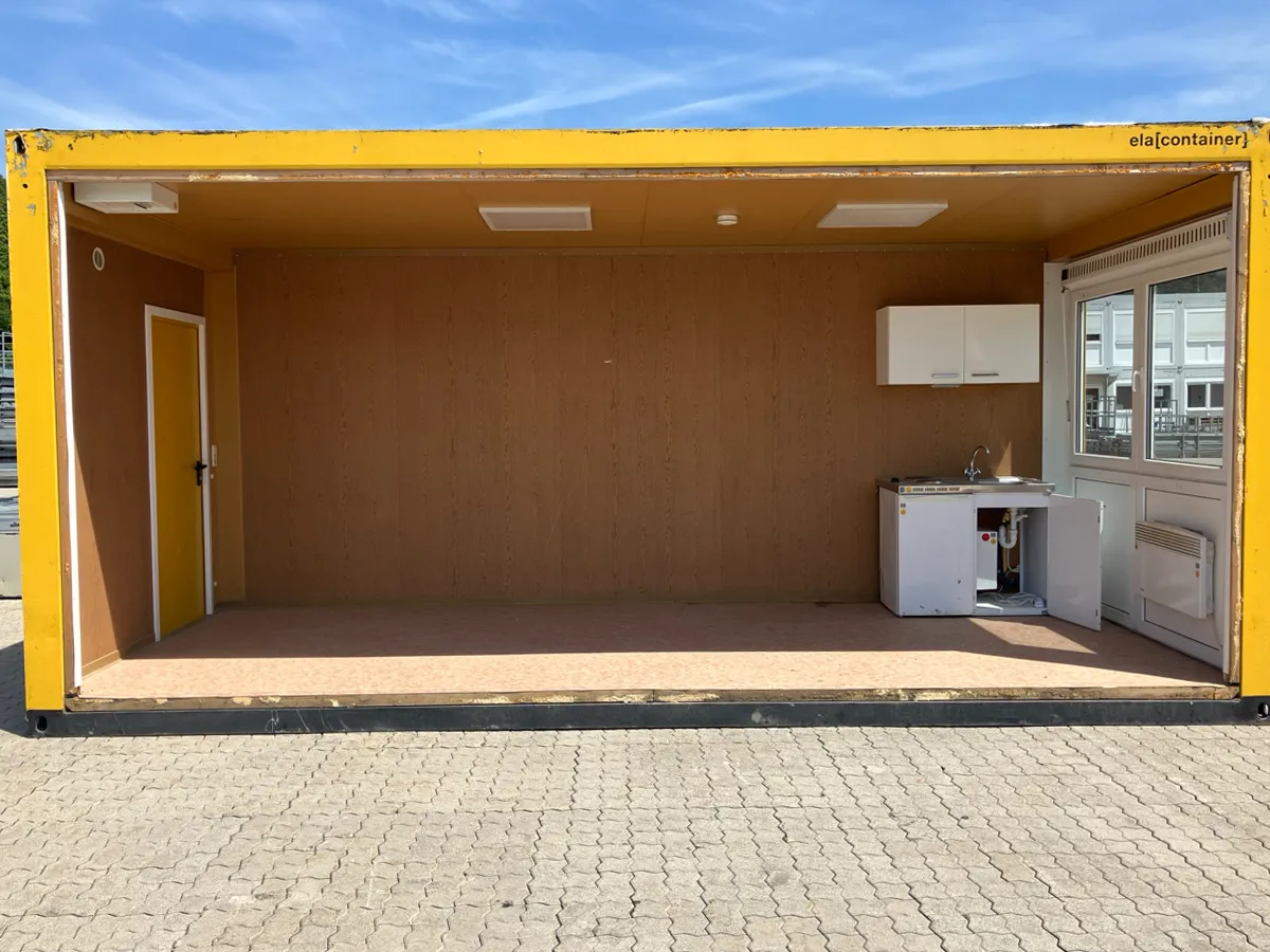 Gebrauchter Bürocontainer Innenansicht teiloffen mit Holzpaneelen, Küchenzeile und Fenstern
