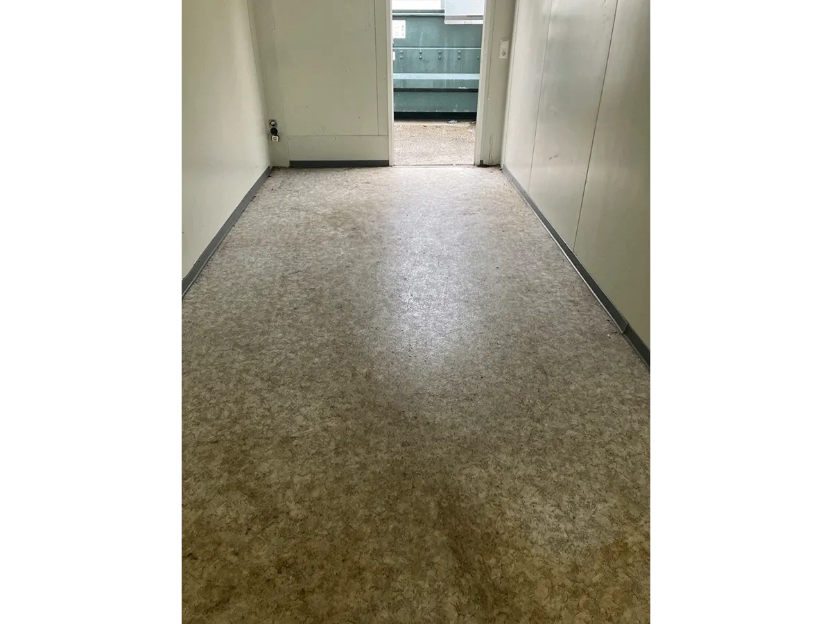 Gebrauchter Bürocontainer Innenraum mit Vinylboden und offener Eingangstür