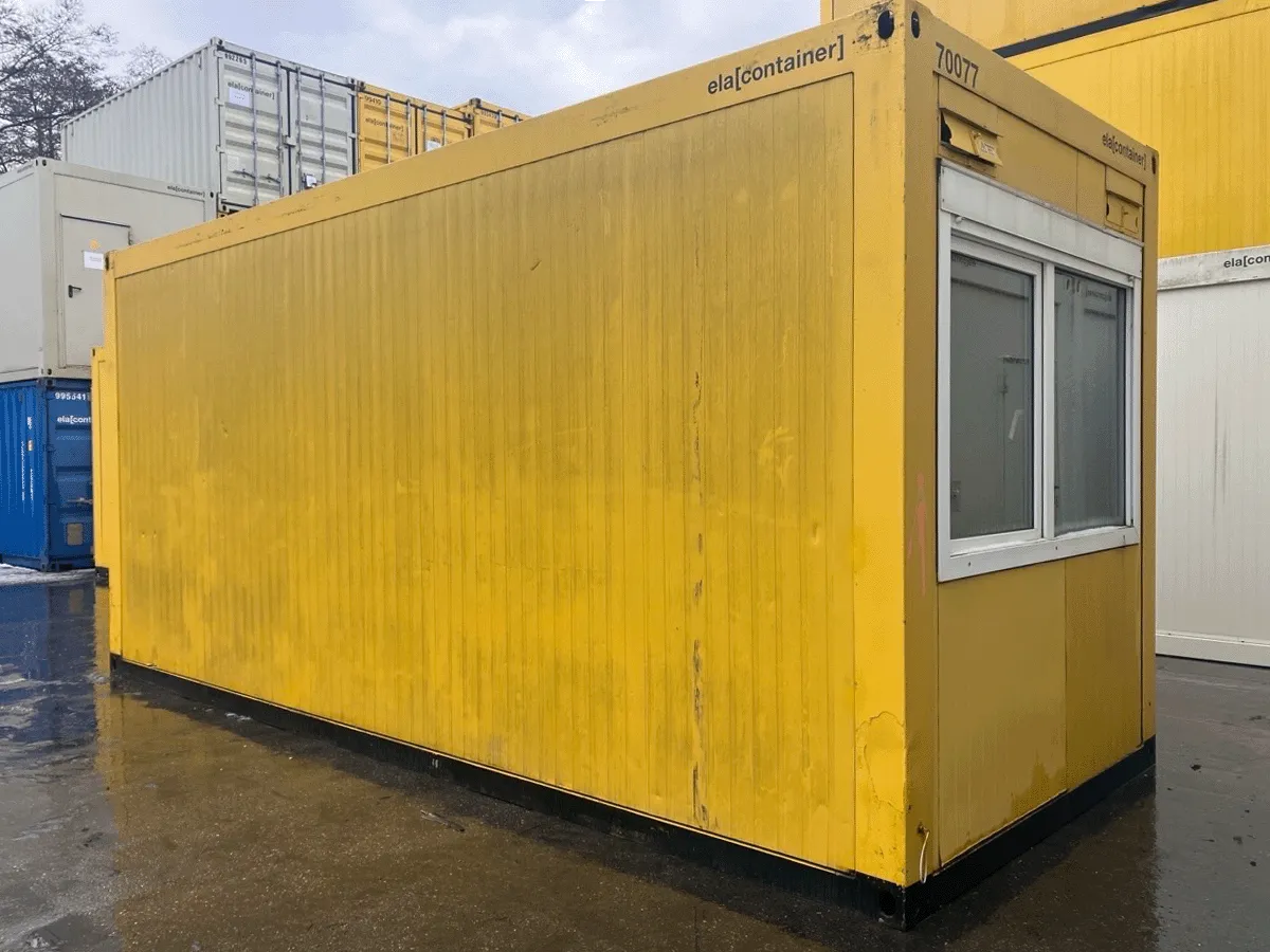 Außenansicht eines gebrauchten gelben 20-Fuß-Bürocontainers mit Doppel-Schiebefenster und heruntergelassenem Rollladen.