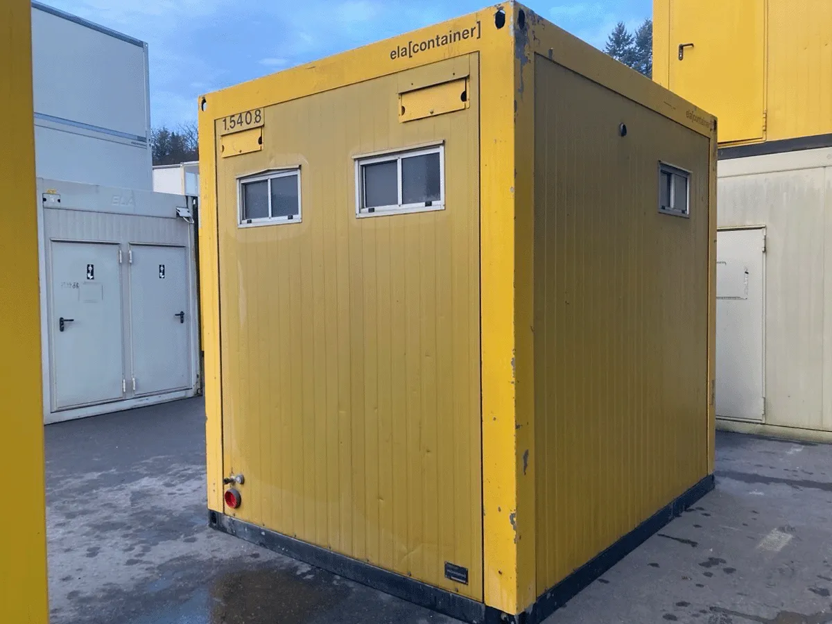 Rückseite Gelber Sanitärcontainer mit zwei Toilettüren auf Baustelle