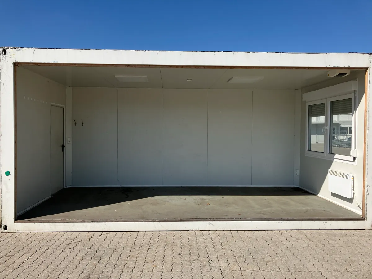 Gebrauchter Bürocontainer Innenansicht teiloffen mit weißen Wänden und Fenster