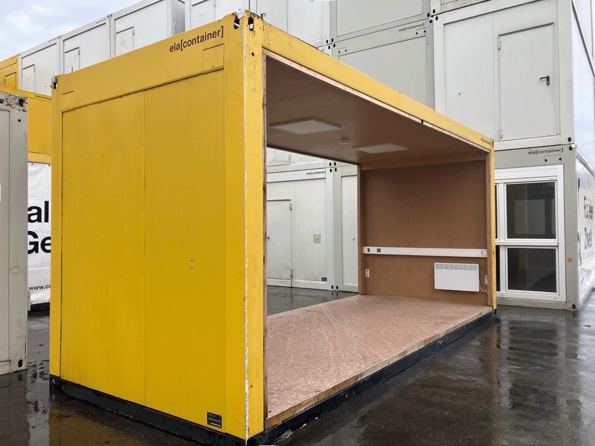 Gebrauchter 20 Fuß Bürocontainer gelb mit offener Front, Heizkörper und Fenster – Seitenansicht auf dem Containerplatz