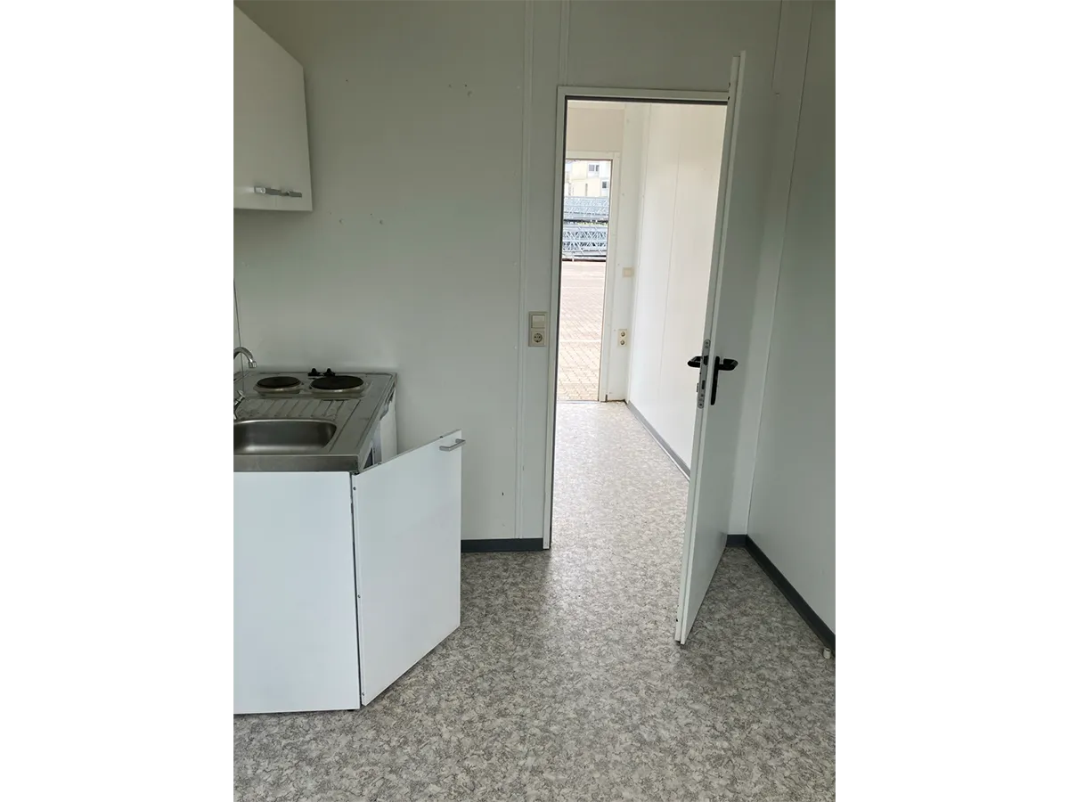 Gebrauchter WC-Container Innenansicht mit Teeküche und Blick durch die Tür
