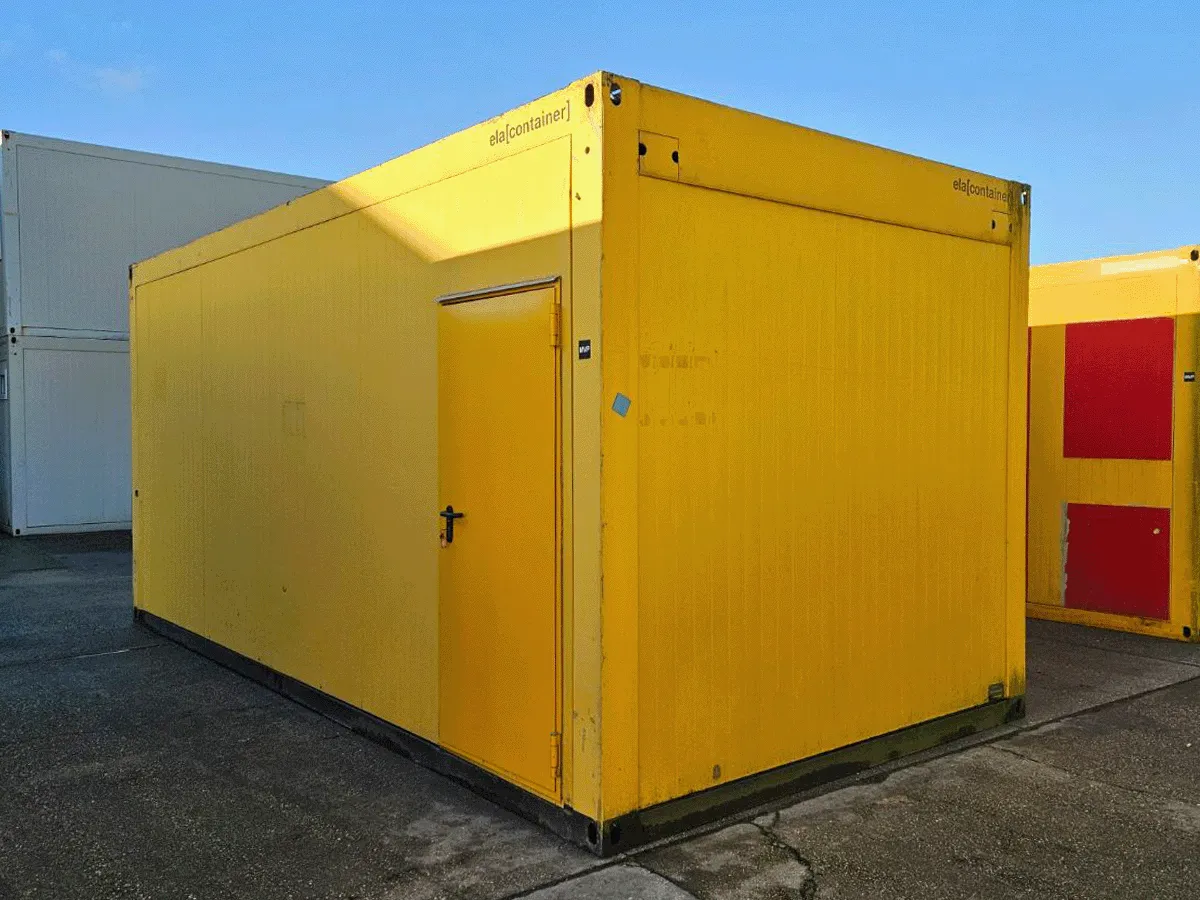 Rückansicht des gelben 20-Fuß-Bürocontainers mit geschlossener Eingangstür auf einem Betriebshof.
