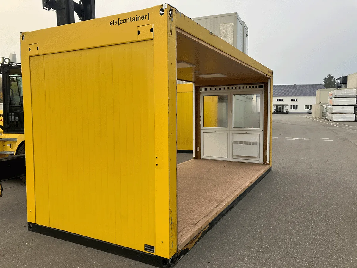 Gebrauchter 20 Fuß Bürocontainer gelb von ELA Container mit offener Seitenfront und Glastür – Außenansicht schräg von hinten