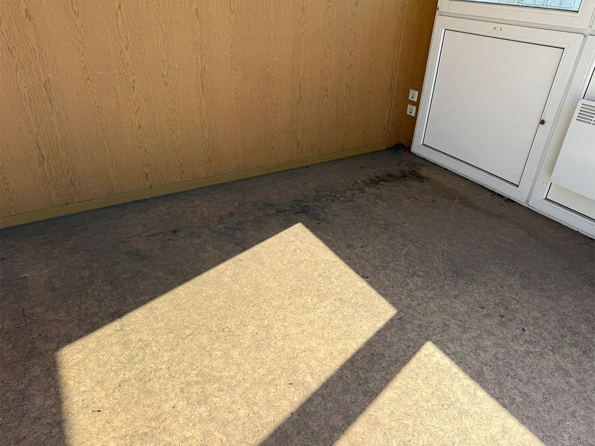 Gebrauchter Bürocontainer Innenansicht mit Steinteppichboden und weißer Tür